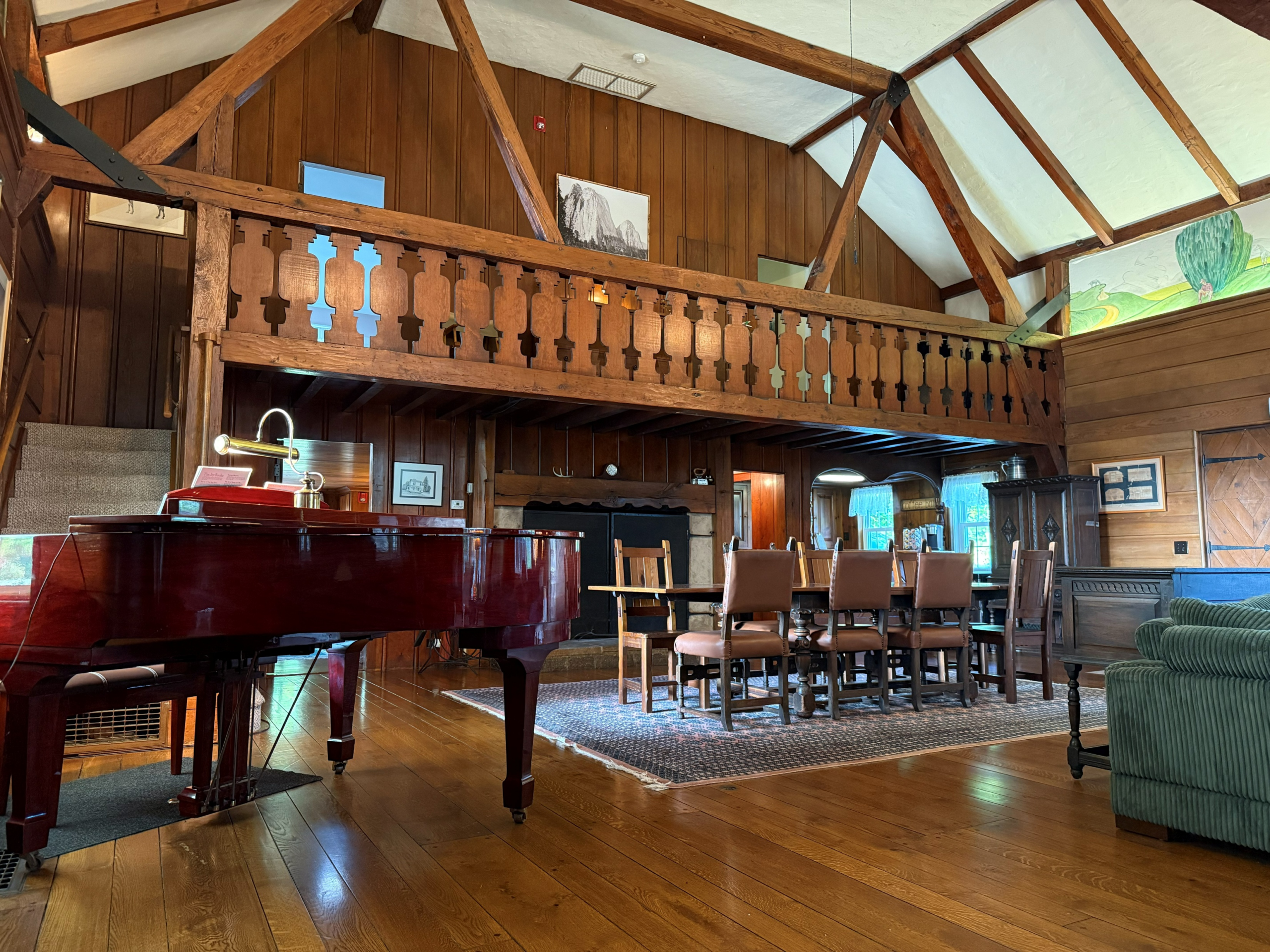 Interior view of Storm King Lodge, including dinning table, piano, and fireplace. Also features loft and 4 bedrooms.